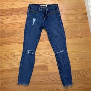 Distressed skinny jeans w/ zipper detail